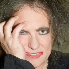 Robert Smith z The Cure, z ręką na twarzy, w makijażu i z burzą włosów. Czyżby zapowiadał nowa płyta?