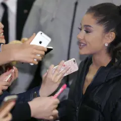 Ariana Grande w Polsce, otoczona fanami z telefonami, którzy chcą zrobić jej zdjęcie.