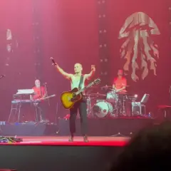 Krzysztof Zalewski koncert: wokalista z gitarą na scenie, zespół gra, tłum szaleje.