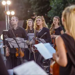 Orkiestra smyczkowa w czerniach, gotowa do koncertu muzyki filmowej. Elegancko, jak na taką okazję.