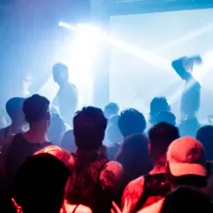 Tłum na koncercie, światła stroboskopowe, DJ Cristobal Pesce za konsolą.