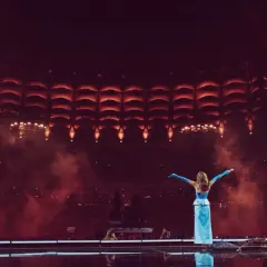 Sanah w błękitnej sukni na tle sceny z czerwonymi światłami. Już wkrótce kolejne sanah koncerty 2026!
