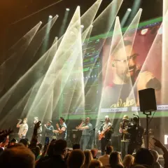 Zespół na scenie podczas koncertu na Next Fest. W tle wielki ekran z transmisją i światła.