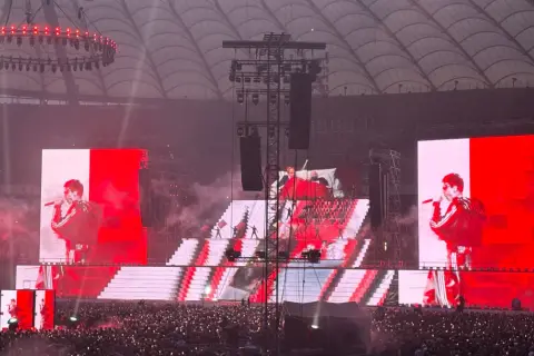 Koncert na stadionie. Wielkie ekrany pokazują artystę, a tłum śpiewa razem z nim. Niesamowita, **mata trasa** koncertowa!