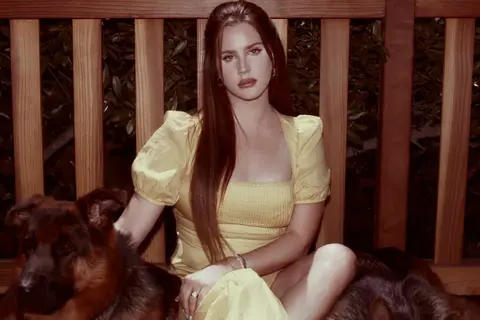 Lana Del Rey w żółtej sukience z psami, jakby czekała na nowy album.