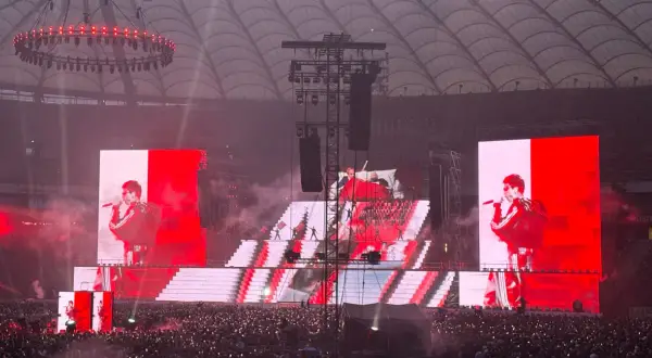 Koncert na stadionie. Wielkie ekrany pokazują artystę, a tłum śpiewa razem z nim. Niesamowita, **mata trasa** koncertowa!