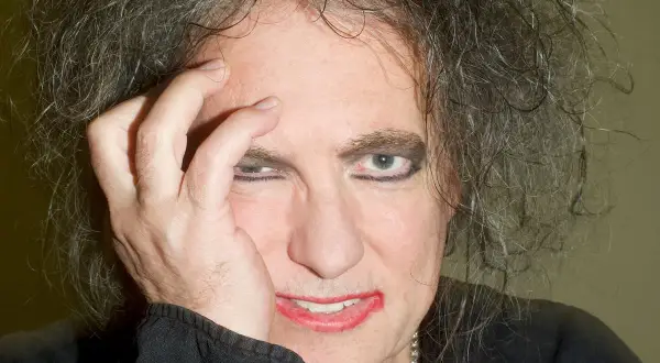 Robert Smith z The Cure, z ręką na twarzy, w makijażu i z burzą włosów. Czyżby zapowiadał nowa płyta?