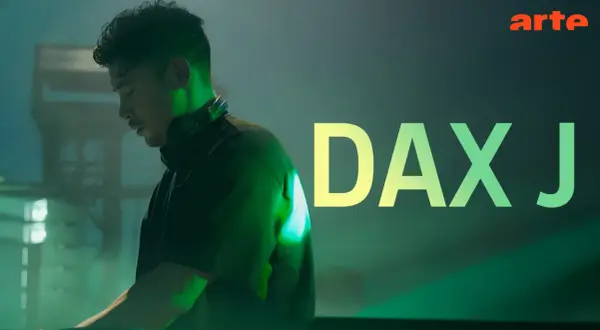 Dax J, DJ w słuchawkach, w zielonym świetle, z napisem "DAX J" i logo Arte.