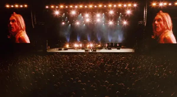 Koncertowa scena z Iggy Popem na ekranach, tłum fanów i zespół gotowy do występu. To musi być niezapomniany off festival lineup!