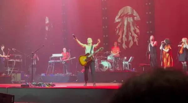 Krzysztof Zalewski koncert: wokalista z gitarą na scenie, zespół gra, tłum szaleje.