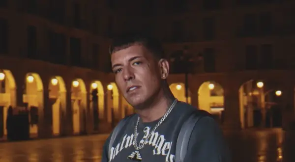 Sentino, znany z kontrowersyjnej **biografii**, w ciemnej scenerii miejskiej.