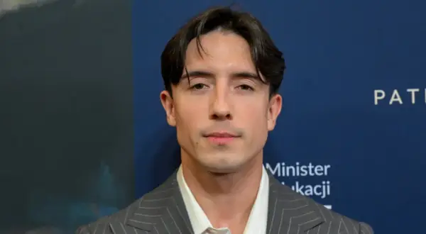 Dawid Kwiatkowski w garniturze, zapowiada swoją nową piosenkę.