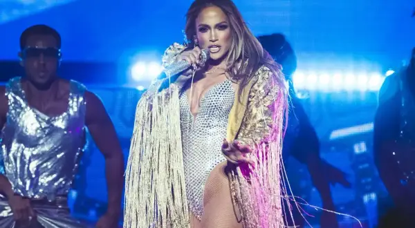 Jennifer Lopez w błyszczącym stroju na scenie, jakby właśnie dała koncert dla fanów w Polsce.