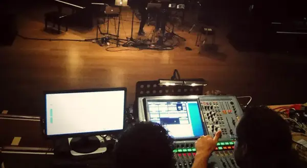 Dwie osoby przy konsolecie dźwiękowej, przygotowujące scenę do występu z elementami dub FX.