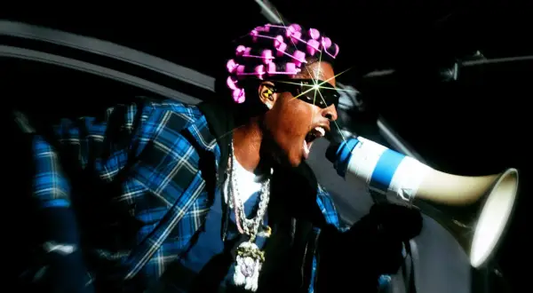 ASAP Rocky z różowymi wałkami na włosach i megafonem zapowiada swój nowy album.
