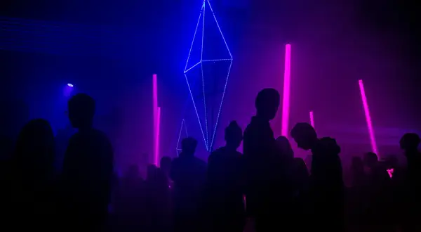 Tłumy bawią się przy neonowych światłach i geometrycznych instalacjach, tworząc atmosferę największych imprez techno na świecie.