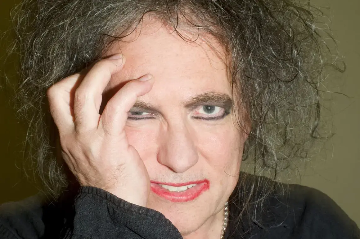 Robert Smith z The Cure, z ręką na twarzy, w makijażu i z burzą włosów. Czyżby zapowiadał nowa płyta?