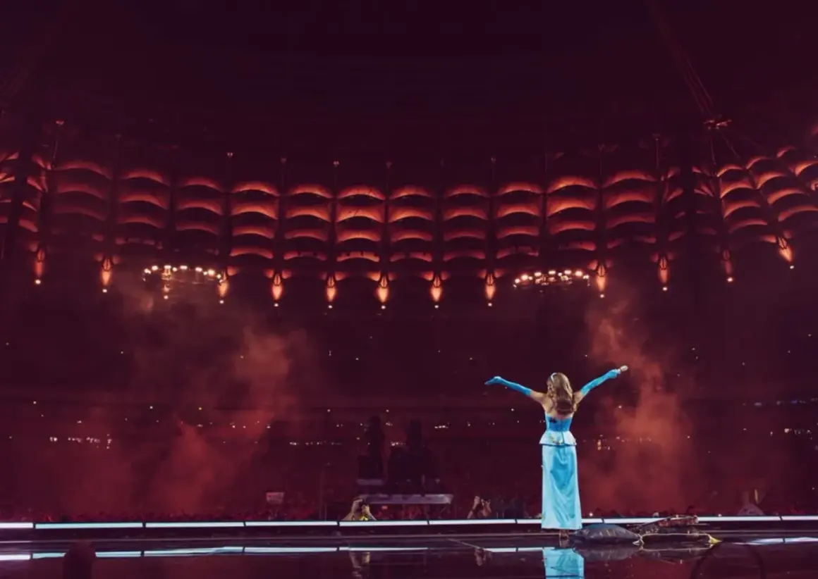 Sanah w błękitnej sukni na tle sceny z czerwonymi światłami. Już wkrótce kolejne sanah koncerty 2026!