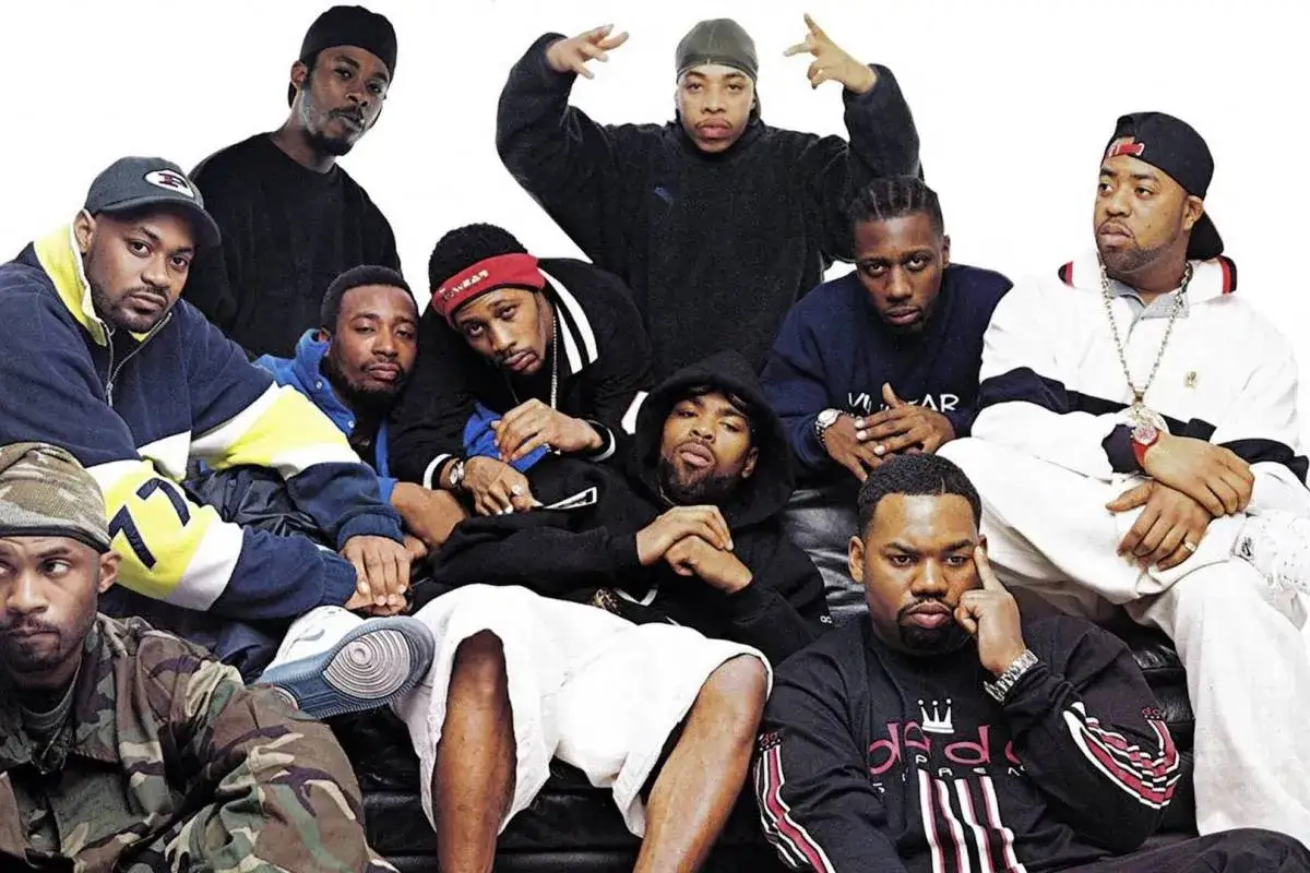Grupa Wu-Tang Clan członkowie pozuje do zdjęcia. Wszyscy ubrani w charakterystyczne stroje z lat 90.
