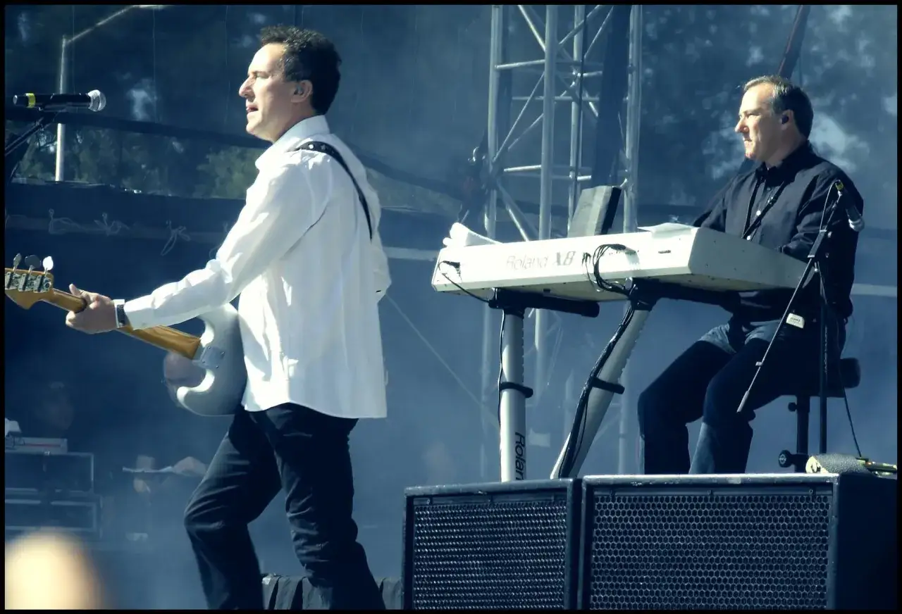 Muzycy zespołu omd na scenie. Jeden gra na gitarze, drugi na keyboardzie Roland.