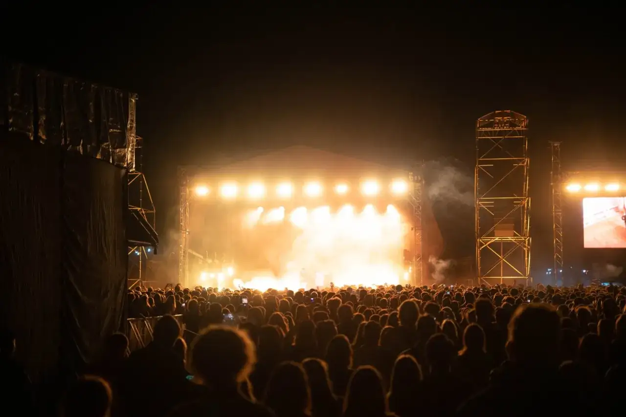 Tłum ludzi na nocnym koncercie, rozświetlonym sceną i dymem. Niezapomniany wiecz&oacute;r na summer punch festival.