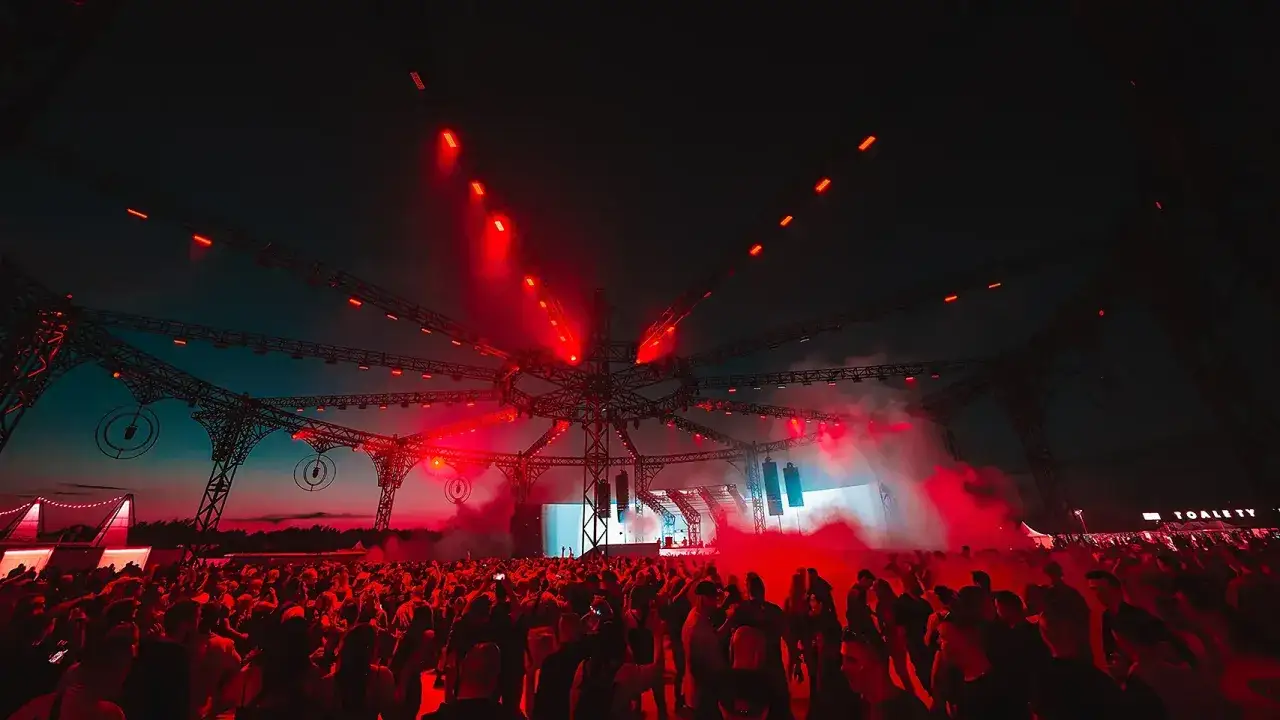 Tłum ludzi na festiwalu pod rozgwieżdżonym niebem, oświetlony czerwonymi światłami. Bilet VIP Sunrise co daje? Lepszy widok i dostęp do ekskluzywnych stref.