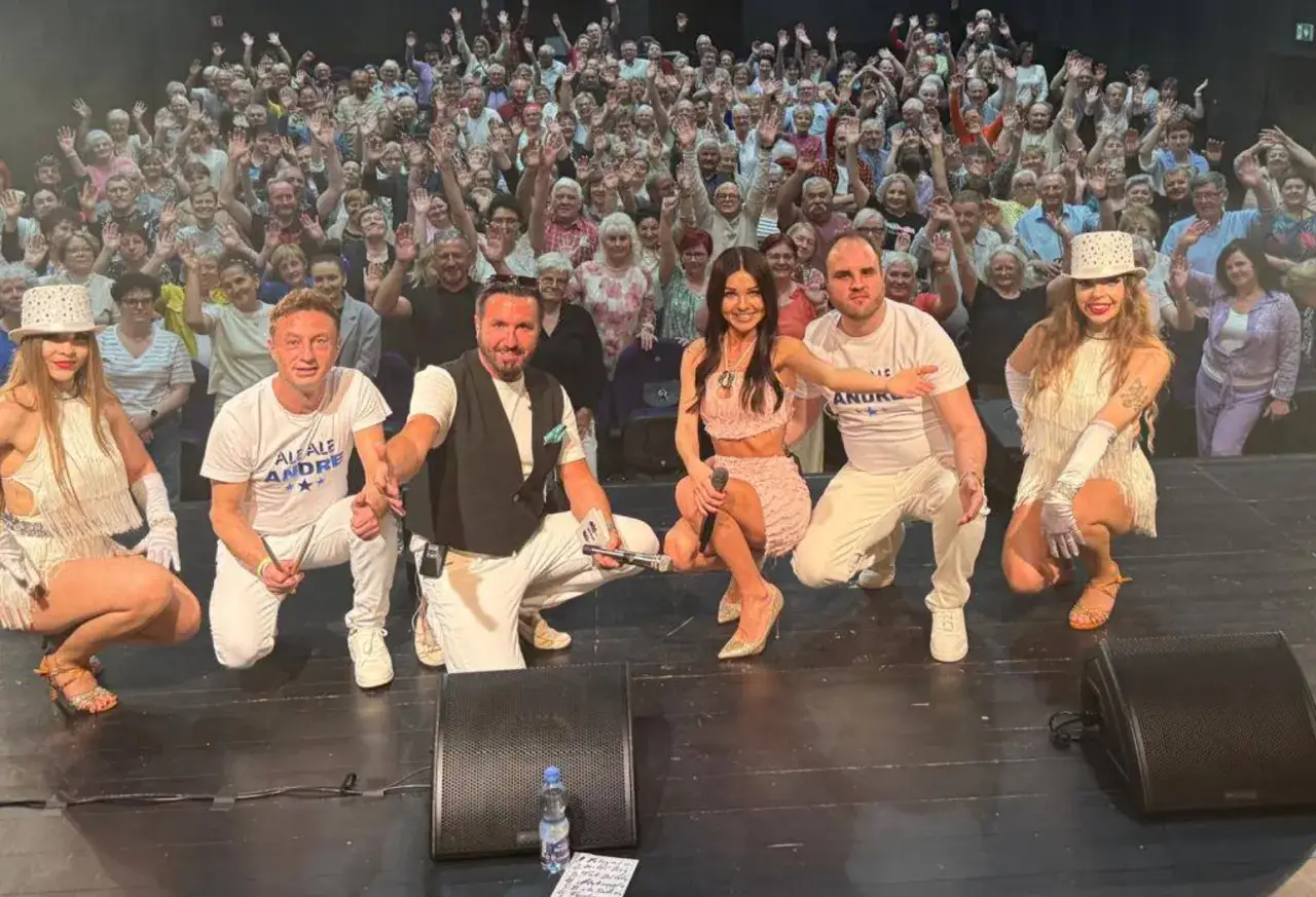 Gwiazdy disco polo, zesp&oacute;ł Andre, pozują na scenie przed rozentuzjazmowaną publicznością.