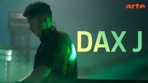 Dax J, DJ w słuchawkach, w zielonym świetle, z napisem "DAX J" i logo Arte.