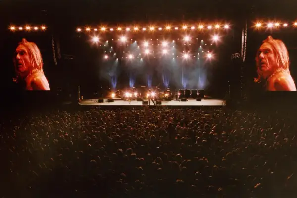 Koncertowa scena z Iggy Popem na ekranach, tłum fanów i zespół gotowy do występu. To musi być niezapomniany off festival lineup!