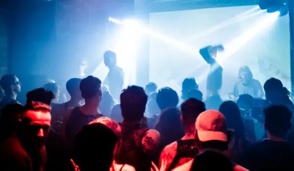 Tłum na koncercie, światła stroboskopowe, DJ Cristobal Pesce za konsolą.