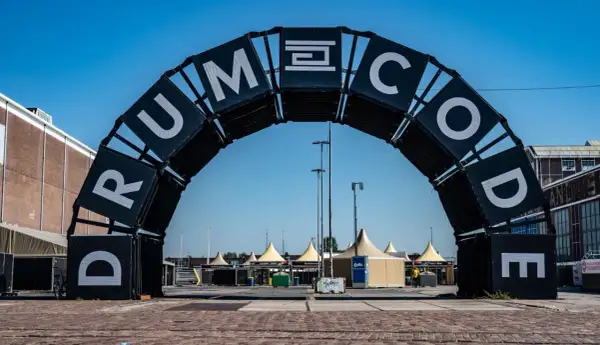 Brama festiwalowa z napisem "DRUMCODE". Wyobraź sobie, że Adam Beyer właśnie przez nią przechodzi, by rozpocząć swój set.