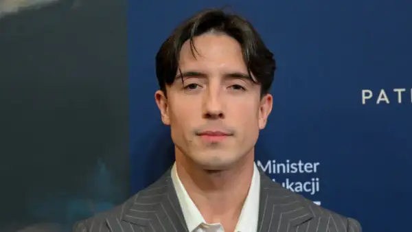 Dawid Kwiatkowski w garniturze, zapowiada swoją nową piosenkę.
