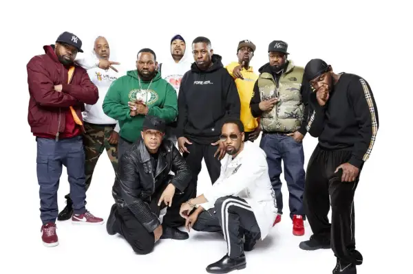 Grupa Wu-Tang Clan członkowie pozuje do zdjęcia. Wszyscy ubrani są w charakterystyczne dla hip-hopu stroje.