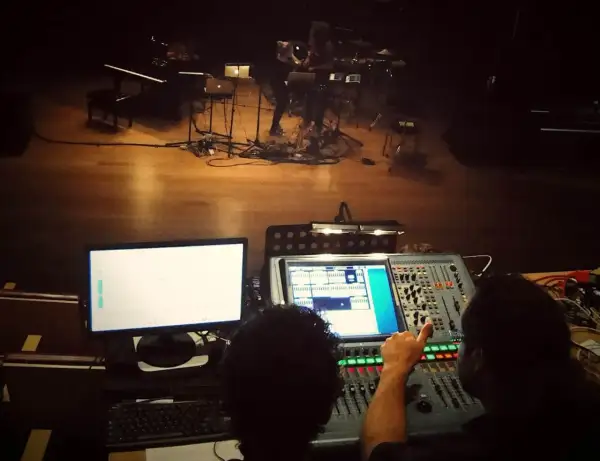 Dwie osoby przy konsolecie dźwiękowej, przygotowujące scenę do występu z elementami dub FX.