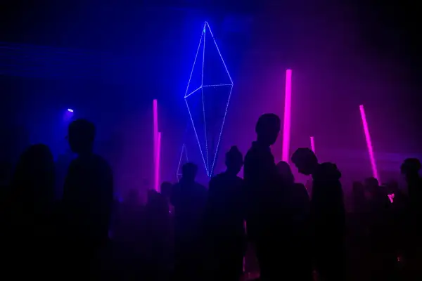 Tłumy bawią się przy neonowych światłach i geometrycznych instalacjach, tworząc atmosferę największych imprez techno na świecie.